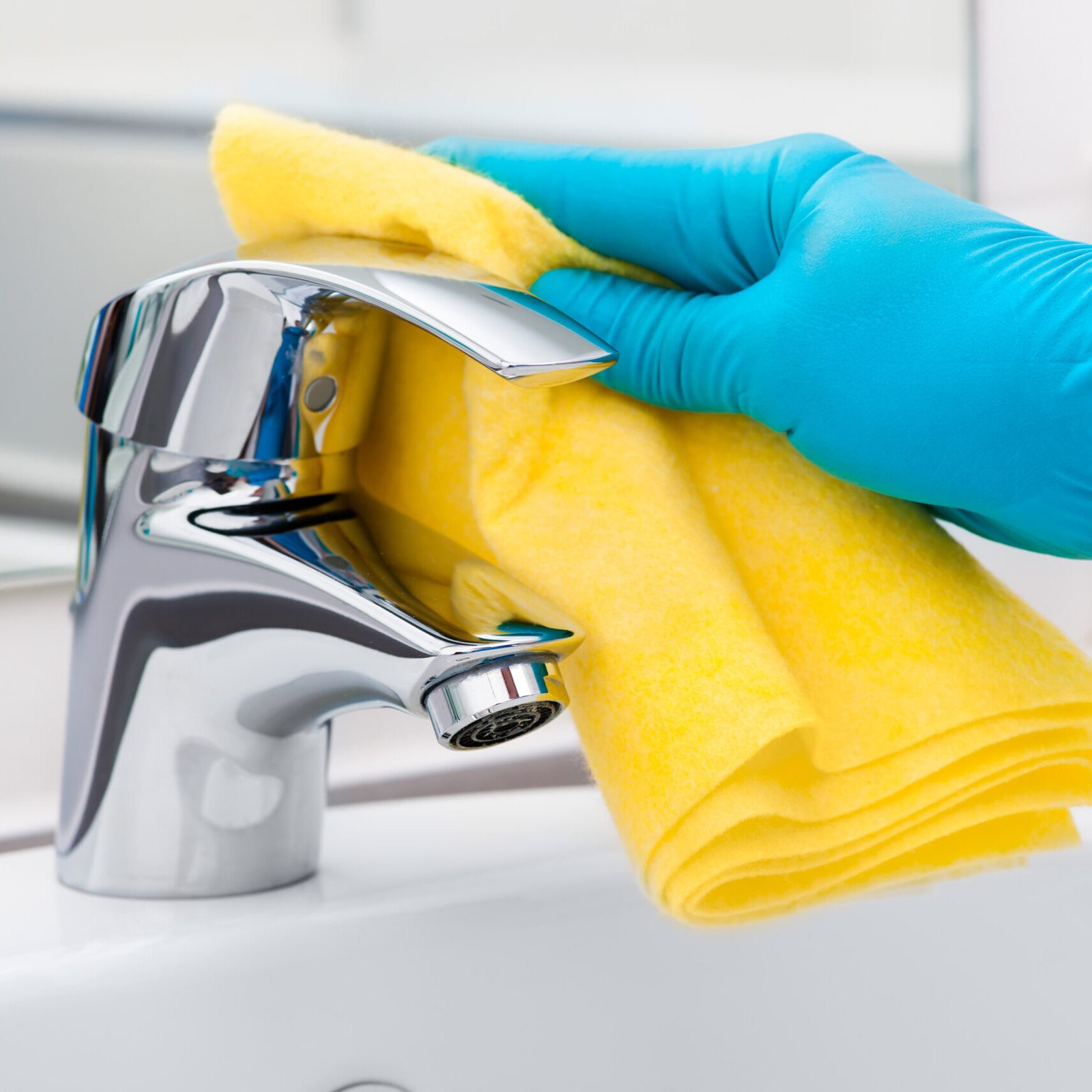 Woman doing chores in bathroom, cleaning tap